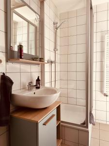 a white bathroom with a sink and a shower at Apartment Altstadt Freiberg in Freiberg