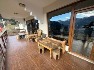 a room with tables and chairs and a view of mountains at Meşeiçi Butik Aile Otel in Macka