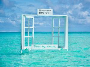 an open door to the ocean with a sign in the water at Constance Moofushi Maldives - All Inclusive in Himandhoo 