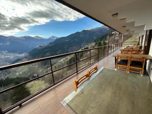 a balcony with tables and chairs and a view of mountains at MEŞEİÇİ BUTiK HOTEL in Macka