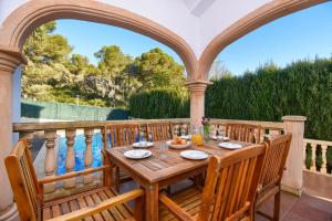 y balcón con mesa y sillas de madera. en Monte Violeta, en Jávea