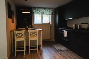 a kitchen with a counter and a table with two stools at Villa Rosa - Garden in Detmold