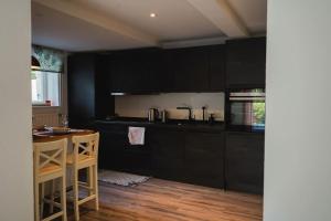 a kitchen with black cabinets and a wooden floor at Villa Rosa - Garden in Detmold