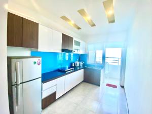 uma cozinha com um frigorífico branco e armários azuis em Căn Hộ 3 phòng ngủ View Biển em Nha Trang