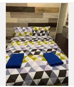 1 dormitorio con 1 cama con almohadas azules en Kasama Holiday Lets between Glasgow and Edinburgh en Kirk of Shotts