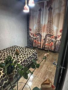 a bedroom with a bed and a curtain with the eiffel towers at Квартира in Ustʼ-Kamenogorsk