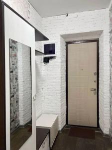 a bathroom with a mirror and a white brick wall at Квартира in Ustʼ-Kamenogorsk