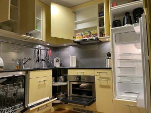 a kitchen with yellow cabinets and an oven at Ferienwohnung Efibach 41 in Silenen