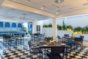 a restaurant with tables and chairs on a checkered floor at Maan Vilas By Stone Wood in Udaipur