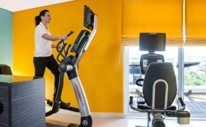 a woman running on an exercise bike in a room at Hotel Elbflorenz Dresden in Dresden