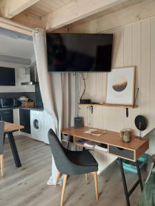 einen Schreibtisch mit Stuhl und einen TV an der Wand in der Unterkunft Gite Marigot in Bazincourt-sur-Saulx