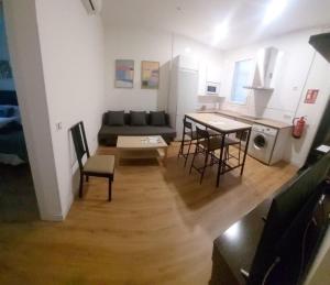 ein Wohnzimmer mit einem Sofa, einem Tisch und Stühlen in der Unterkunft Apartamento Roco in Madrid