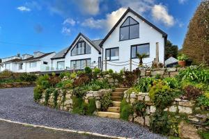 a white house with a stone wall and some plants at Finest Retreats - Blue Seas in Mousehole