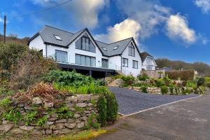 a large white house with a stone wall at Finest Retreats - Blue Seas in Mousehole