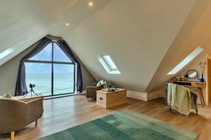 a living room with an attic with a large window at Finest Retreats - Blue Seas in Mousehole