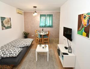 Apartment Welcome في Karaburma: غرفة صغيرة بها سرير وطاولة
