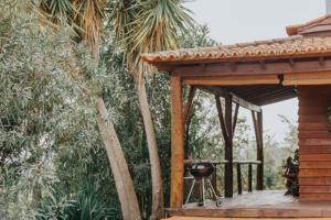 a grill on a wooden deck next to a cabin at Simple Wooden house in Moçarria