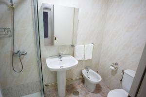 uma casa de banho com um lavatório, um WC e um chuveiro em A Casiña de Juan em Corcubión
