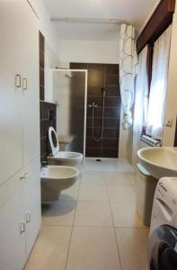 a bathroom with two sinks and a toilet and a shower at Appartamento in centro in Vinchiaturo