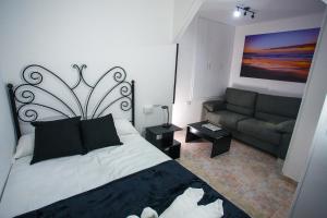 um quarto com uma cama e um sofá em A Casiña de Juan em Corcubión