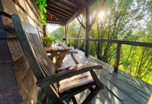 a wooden rocking chair sitting on the porch of a cabin at Simple Wooden house in Moçarria