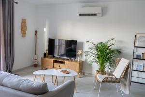 Televízia a/alebo spoločenská miestnosť v ubytovaní La Brise des Îles - Maison neuve avec terrasse