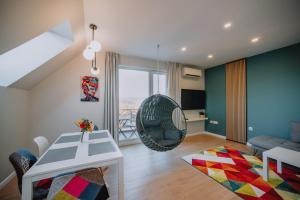 uma sala de estar com uma mesa e uma cadeira em "The House" Апартаменти и Термална зона em Velingrad