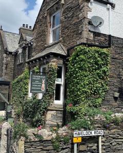 a brick building with ivy on the side of it at Cambridge House room only accommodation for Adults in Windermere