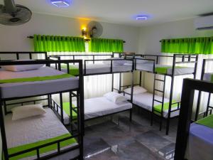 grupa łóżek piętrowych w pokoju z zielonymi zasłonami w obiekcie Havelock City Hostel, Colombo w Kolombo