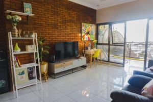 a living room with a television and a brick wall at Amarillo Lembang in Lembang