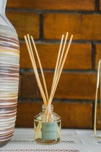 a glass jar with bamboo sticks in it next to a vase at Amarillo Lembang in Lembang