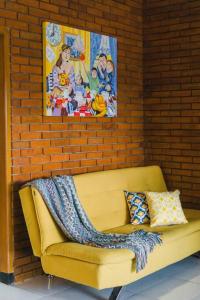 a yellow couch with a blanket on a brick wall at Amarillo Lembang in Lembang