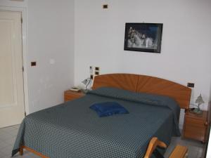 a bedroom with a bed with a blue comforter at Holidays Baia D'Amalfi in Amalfi