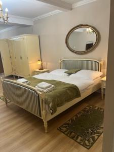 a bedroom with a bed with a mirror on the wall at Pałac Biedrusko in Poznań