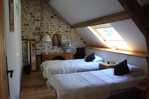 a attic room with three beds and a window at L'Aide Frechu in Mortain