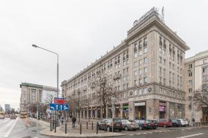 a large building on a city street with parked cars at SuperApart plac Konstytucji 6 in Warsaw