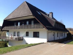 ホイザーンにあるSchwarzwaldhutの黒屋根の大白い家