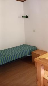 カンポロッソ・イン・ヴァルカナレにあるResidence Tarvisio Camporossoの小さな部屋で、角にベッドが1台あります。