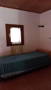 カンポロッソ・イン・ヴァルカナレにあるResidence Tarvisio Camporossoの窓付きの部屋にベッド付きのベッドルーム1室があります。