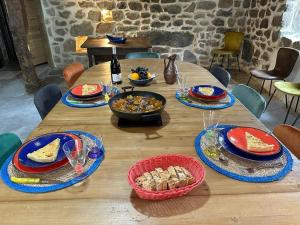 une table en bois recouverte de assiettes et de bols de nourriture dans l'établissement Le Cocon du Vivarais, à Rochepaule
