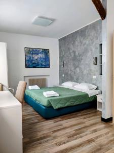 a bedroom with a bed and a wooden floor at Albergo Baffo in Chiuro