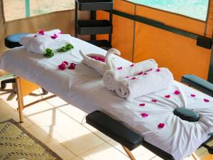 a hospital bed with towels and flowers on it at Tulia Amboseli Safari Camp in Amboseli