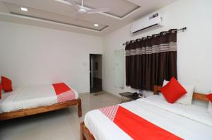 a bedroom with two beds and a ceiling fan at Hotel Kanha Classic, Kanpur in Kānpur