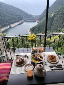 a table with food and a view of a lake at Cà Armonia Luminoso apt con vista panoramica in Mergoscia