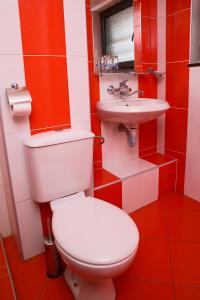 czerwono-biała łazienka z toaletą i umywalką w obiekcie Hotel Zlatograd w mieście Złatograd