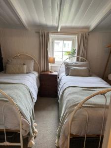 two beds in a small room with a window at Ulva Cottage - Historical BnB in Penola