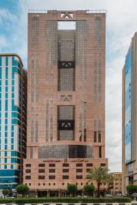 a tall brick building with a ak sign on it at Joury Al Mashaer Hotel in Makkah