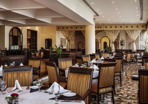 a restaurant with tables and chairs in a room at Corniche Hotel Sharjah in Sharjah