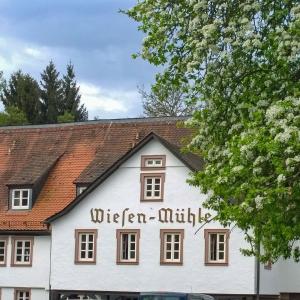 een wit gebouw met de woorden achttien minuten erop bij Hotel Brauhaus Wiesenmühle in Fulda