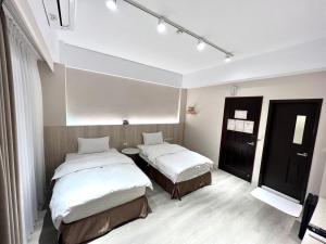 Yujingにある玉井拱月民宿のベッド2台とテーブルが備わる客室です。